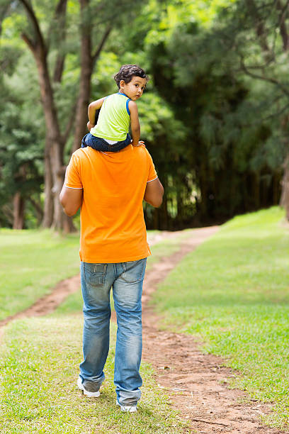 süße kleine junge sitzend auf vaters schultern - baby beautiful little boys carrying stock-fotos und bilder