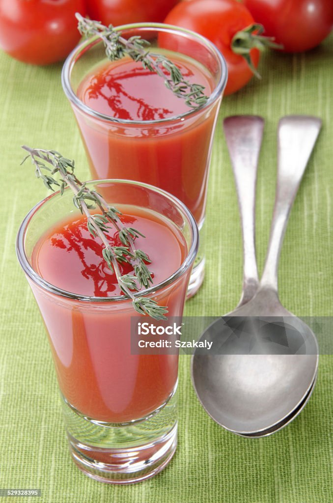 tomato soup in a shot glass tomato soup as appetizer in a shot glass with thyme on green table cloth Appetizer Stock Photo