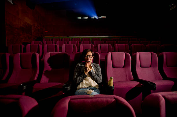 istock young girl eating popcorn while watching a movie 529330641