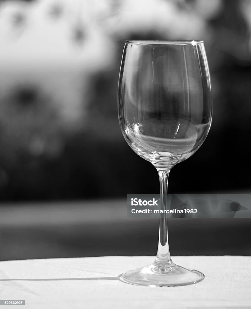 Empty wine glass in grayscale Empty glass on  white tablecloth with blurry, out of focus background, Photo taken outdoors in Alcaidesa,Andalusia, Spain. Andalusia Stock Photo