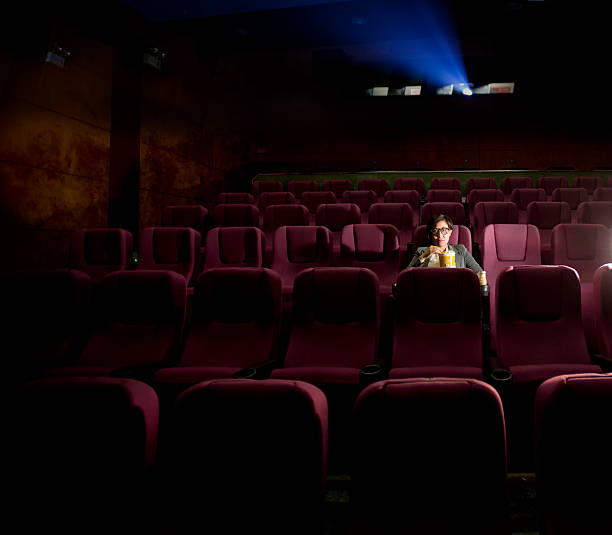 istock young girl eating popcorn while watching a movie 529355119