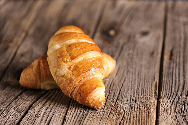 istock Fresh Croissants on wooden rustic background 529356669