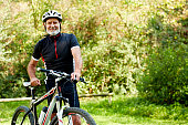 Confident senior man with bicycle in park