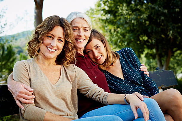 happy family sitting on park bench - three person family fotografías e imágenes de stock