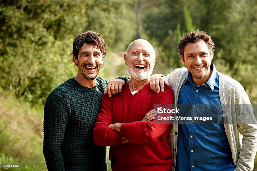 Happy family at park Portrait of cheerful senior man standing with sons at park Only Men Stock Photo
