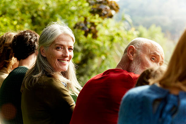 senior woman sitting with family at park - park posing family outdoors fotografías e imágenes de stock