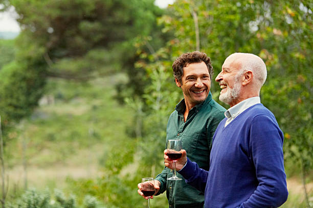 father and son having red wine in park - senior adult imagens e fotografias de stock