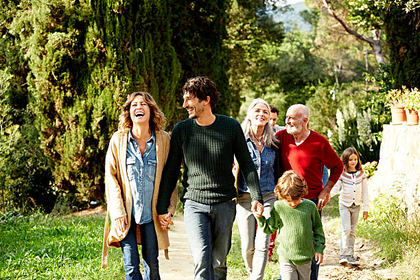 happy family walking in park - grandchild grandparent child senior adult fotografías e imágenes de stock