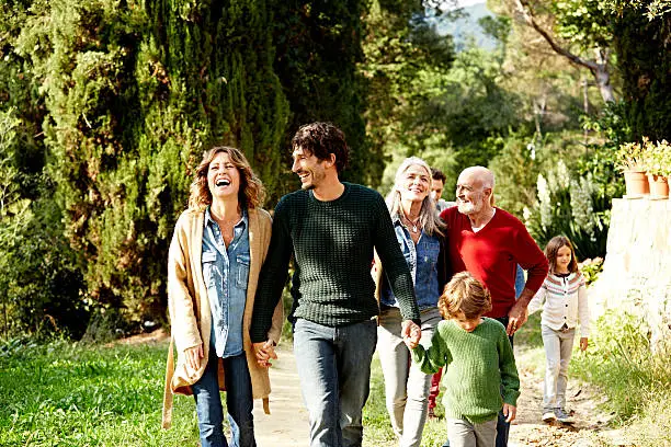 Happy multi-generation family holding hands while walking in park