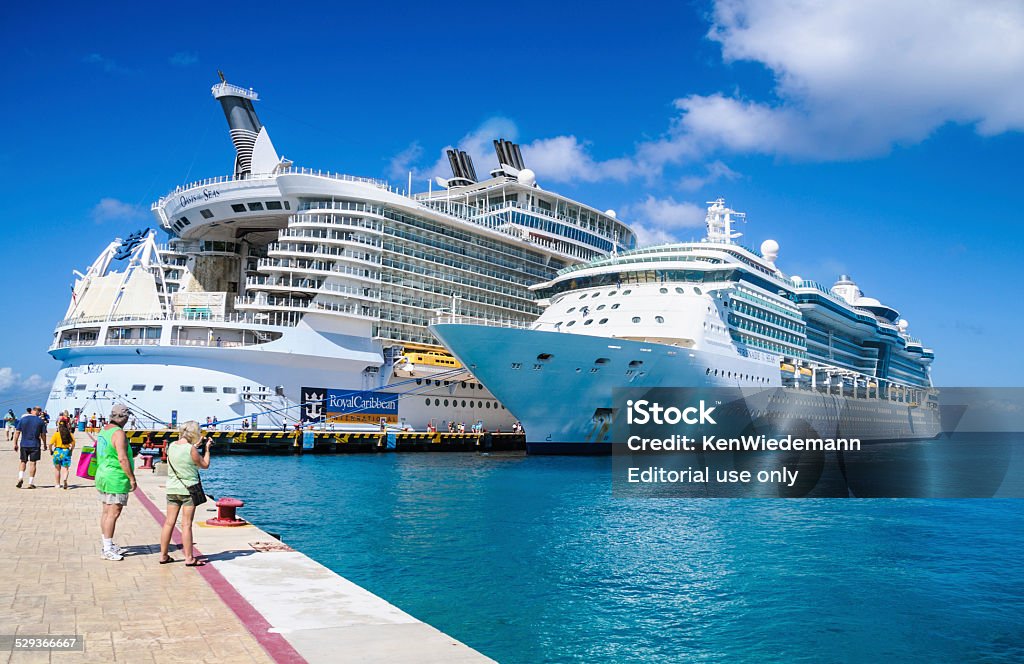 Port of Call - Cozumel Cozumel, Mexico - February 6, 2014: As they return from a day in port, passengers stop to take a quick snapshot of their luxury cruise ship "Seranade of the Seas" while her much larger sister ship "Oasis of the Seas" is docked on the same pier in Cozumel, Mexico. Cruise Ship Stock Photo