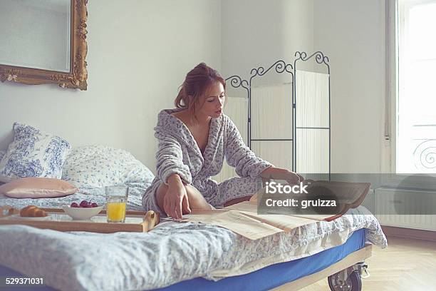 Bella Mujer Joven Con Desayuno Y Lee El Periódico En Ser Foto de stock y más banco de imágenes de Leer