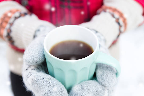 istock cup of tea in hands on mittens on winter background 529381451