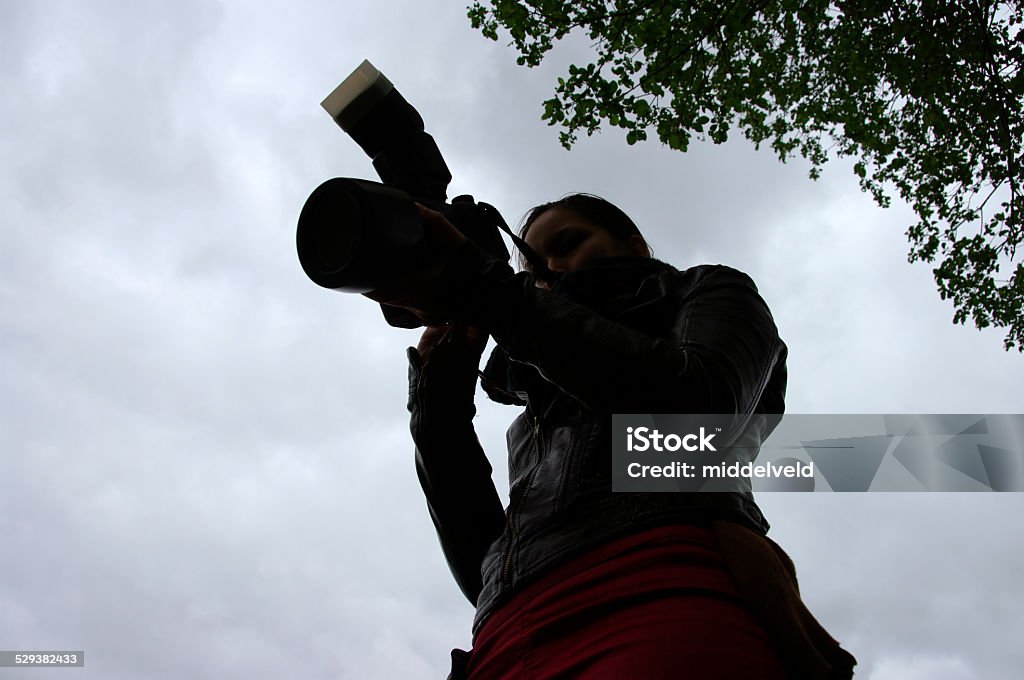 Photographer in action Silhouette of Photographer in action Activity Stock Photo