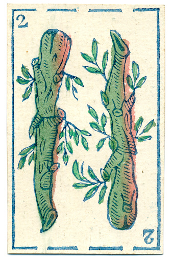 This is the two of clubs / batons (Bastos) from a pack of Mexican Spanish playing cards dated 1846. The distinctive back design is made up of an abstract repeating pattern. This card belongs to a baraja Espanola (Spanish deck of cards with a traditional design). The four suits are oros (gold coins), copas (cups or trophies), espadas (swords) and bastos (clubs or batons, shown here). A full deck consists of 40 cards because there are no 8s or 9s, and the first court card counts as 10 (not 11). Packs of this kind, based on the Italian card system, have been around since the 15th century. These club / baton designs are more life-like than in later representations (see example below). Clubs or batons (in Spanish (bastos)) are thought to represent the peasant class in mediaeval society. Baraja (Spanish decks) are also used like tarot cards in fortune telling / cartomancy / divination.