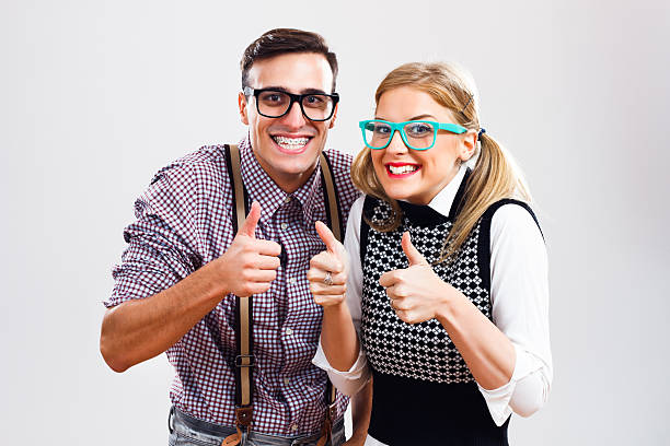 Successful nerds Happy nerdy couple showing thumbs up. nerd stock pictures, royalty-free photos & images