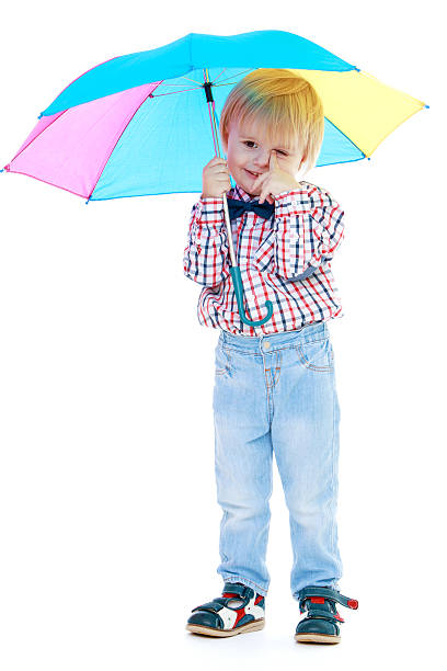 istock Little boy stands under a colorful umbrella. 529386069