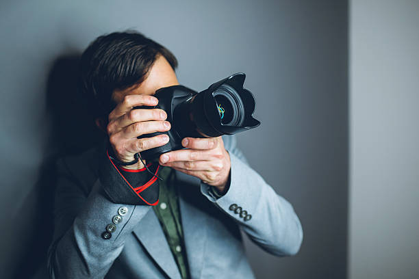 istock Nerdy young man taking photographs with a digital camera 529397046