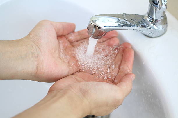 istock hands with water splashing from tap, fresh water, save water 529398018