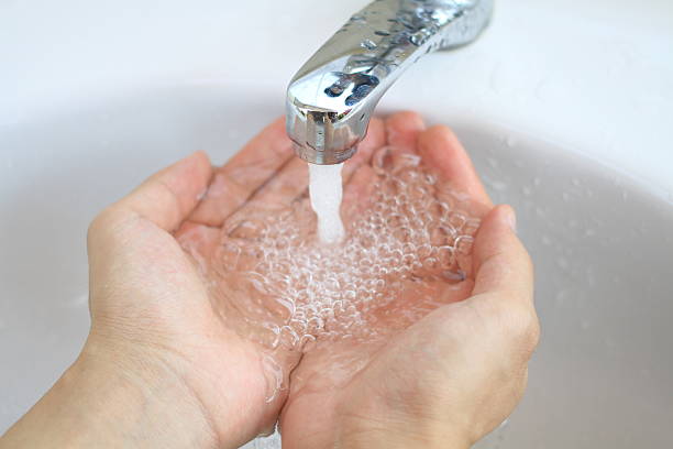 istock hands with water splashing from tap, fresh water, save water 529398074