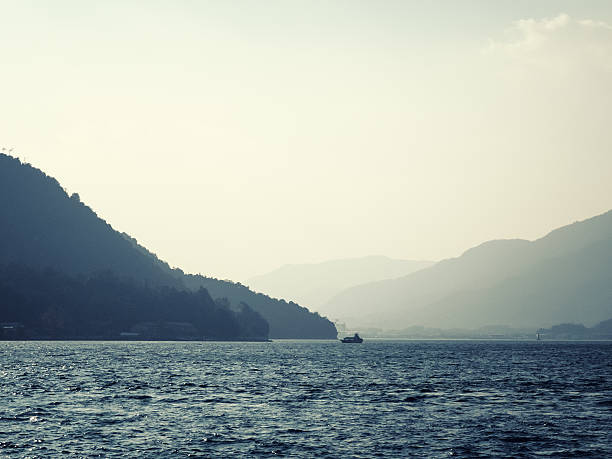 istock Hazy lake with ship on horizon 529399634