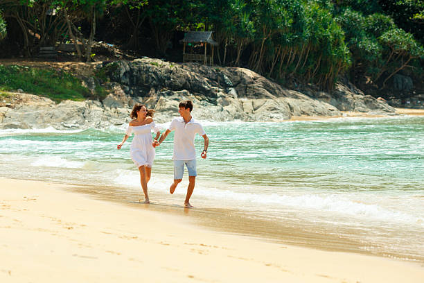 istock happy couple running on tropical beach 529403607