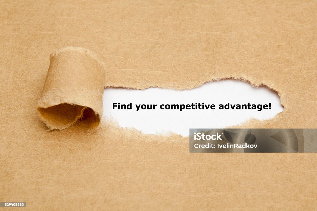 Find your competitive advantage Find your competitive advantage! appearing behind torn brown paper. Analyzing Stock Photo