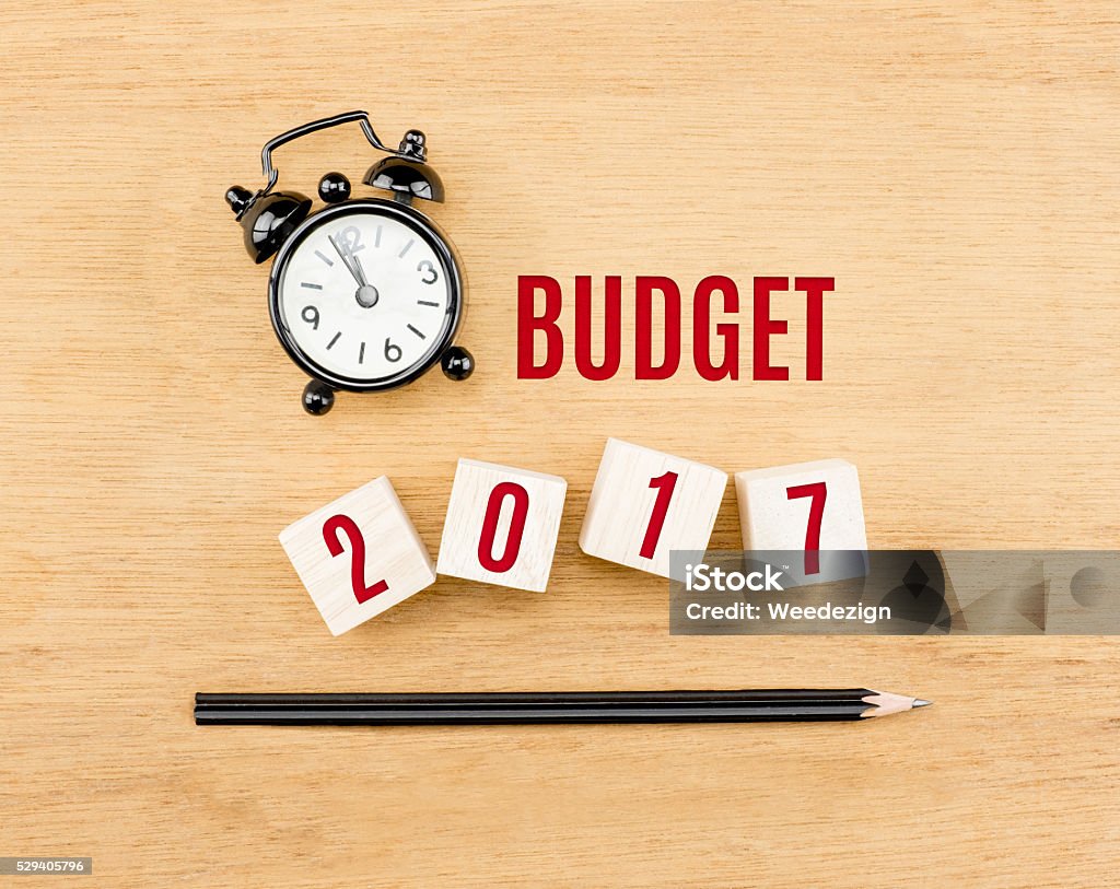 Budget 2017 year on cube with pencil and clock Budget 2017 year on wood cube with pencil and clock top view on wood table,New year business concept. 2017 Stock Photo