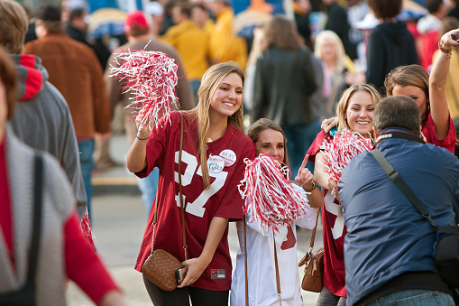 Atlanta, GA, USA - December 6, 2014:  Female University of Alabama fans dressed in crimson pose for a photo as they walk toward the Georgia Dome to watch the SEC Championship game against Missouri.