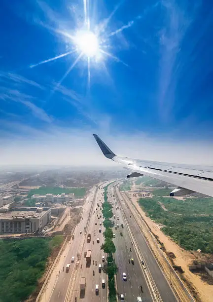 View through the window of a passenger plane flying above Delhi Gurgaon highway, taken just a minute before landing at the New Delhi Airport T3 terminal