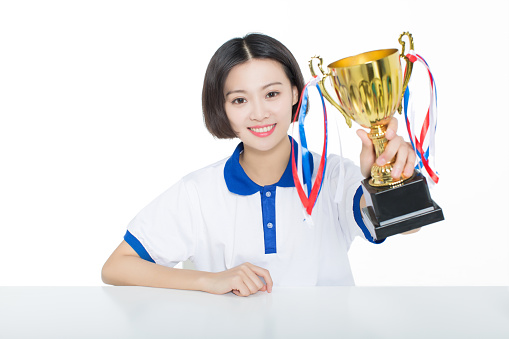 chinese female students in the classroom, took the hands of a golden trophy on white background