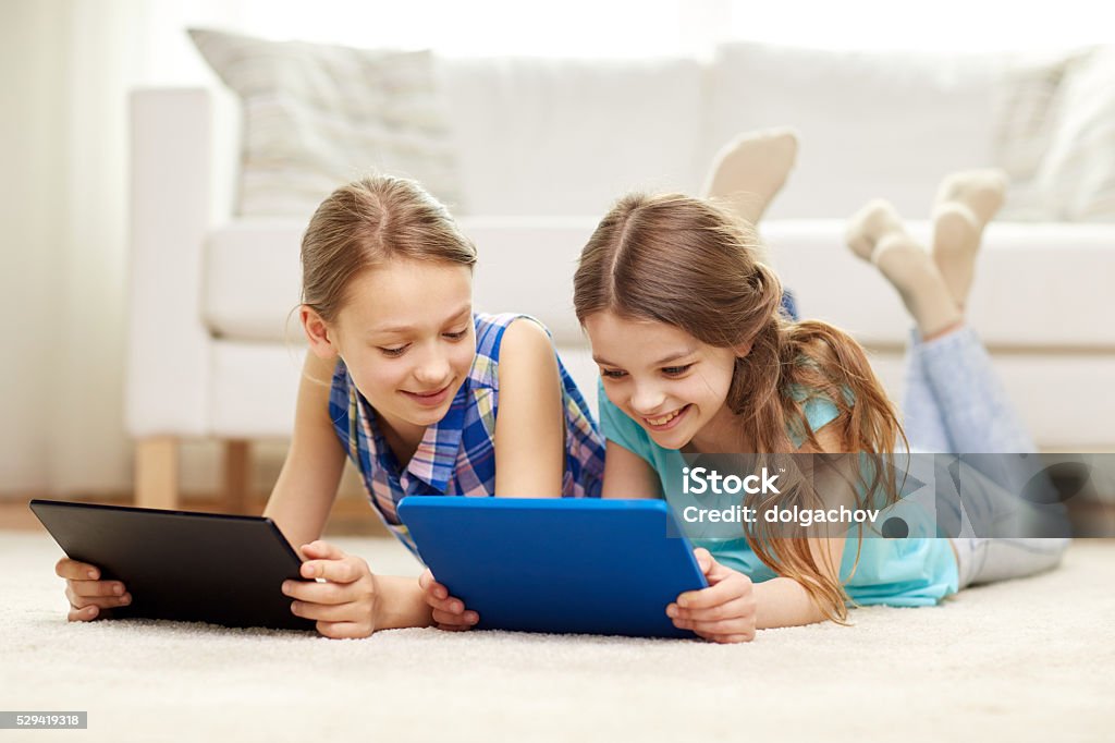 Las niñas feliz con Tablet PC en casa tendido sobre piso - Foto de stock de Niñas libre de derechos