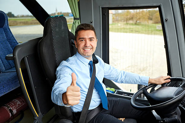 happy driver driving bus and snowing thumbs up transport, tourism, road trip and people concept - happy driver driving intercity bus and snowing thumbs up coach bus photos stock pictures, royalty-free photos & images