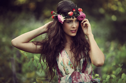 romantic beautiful woman summer portrait with wreath of flowers in vineyard