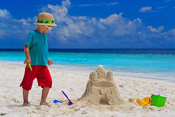 istock little boy building sand castle on beach 529420355