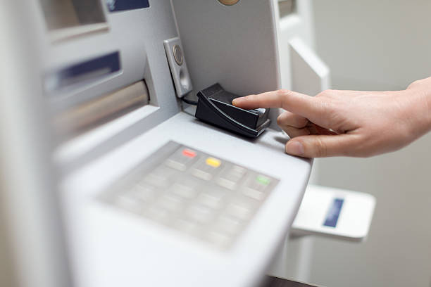 Fingerprint recognition technology on ATM Woman uses fingerprint recognition technology to withdraw cash from ATM fingerprint scanner photos stock pictures, royalty-free photos & images