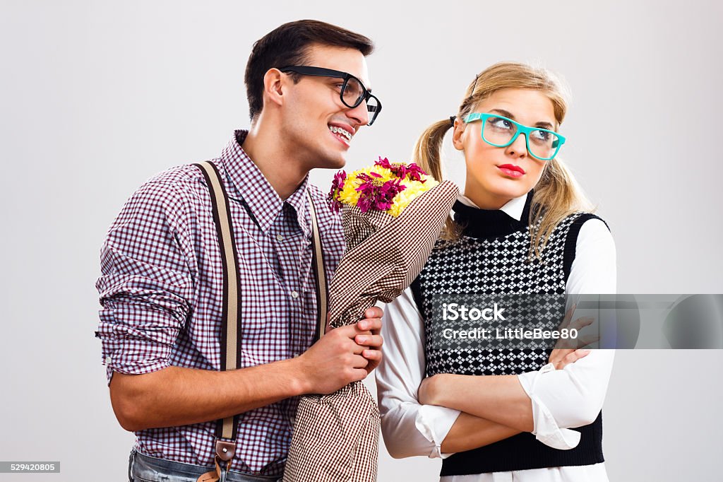Please forgive me my dear! Nerdy man is giving  a bouquet of flowers to his girlfriend,he had made a mistake and he is hoping that she will forgive him. Rejection Stock Photo