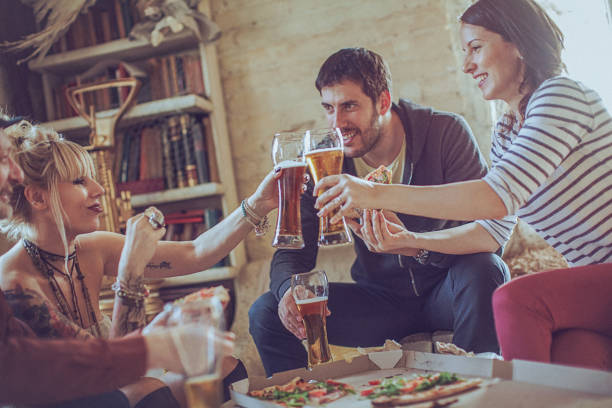 istock Friends enjoying time eating pizza and drinking beer together 529422050
