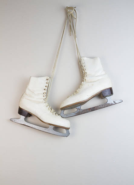 istock Old white ice skates hanging on the wall 529422532