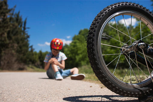 Boy is lying hurt after a bicycle accident. Kids safety concept