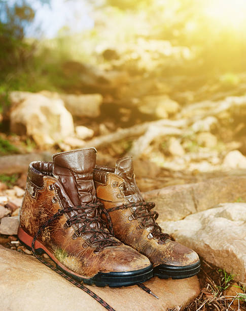 istock Scuffed and worn but reliable hiking boots resting on rock 529427434