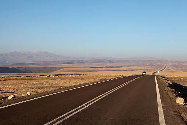 Panamerican road (ruta 5) in Chile leading through the Atacama Desert - a car passing