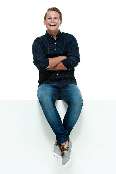 istock Cheerful male sitting on box with arms crossed 529436375