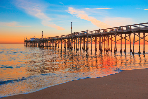 Incoming tide reflects the sunsent at Balboa Pier in Newport Beach, CA