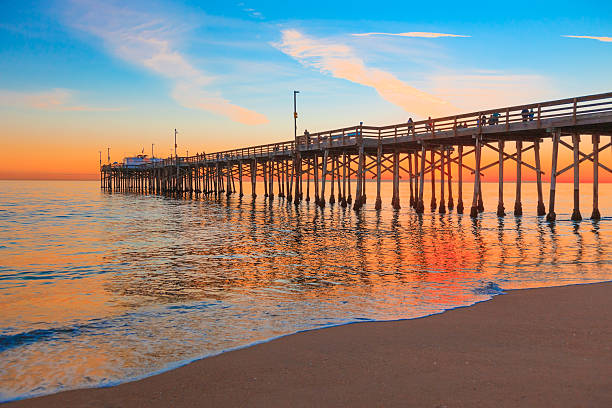 Newport Beach Balboa Pier, RTE 1,Orange County California Incoming tide reflects the sunsent at Balboa Pier in Newport Beach, CA newport beach california stock pictures, royalty-free photos & images