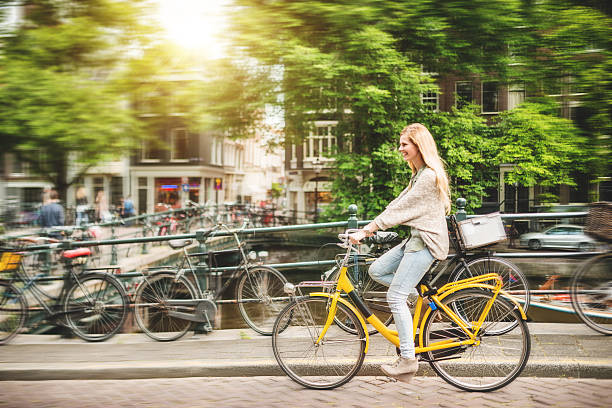 woman tourist cycling on amsterdam woman tourist cycling on Amsterdam jordaan amsterdam stock pictures, royalty-free photos & images