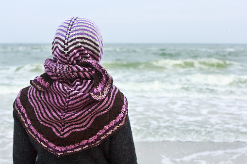 Girl in a shawl on a sea bank