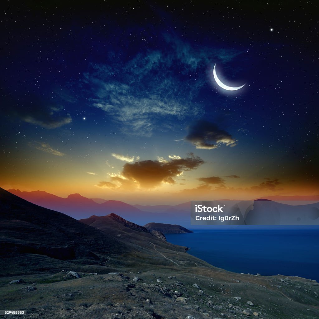 Sunrise with moon Beautiful sunrise in mountains and sea, glowing horizon, moon and bright stars in dark blue sky. Elements of this image furnished by NASA http://visibleearth.nasa.gov Crescent Stock Photo