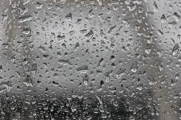 Water droplets on a rainy day collecting on a window.