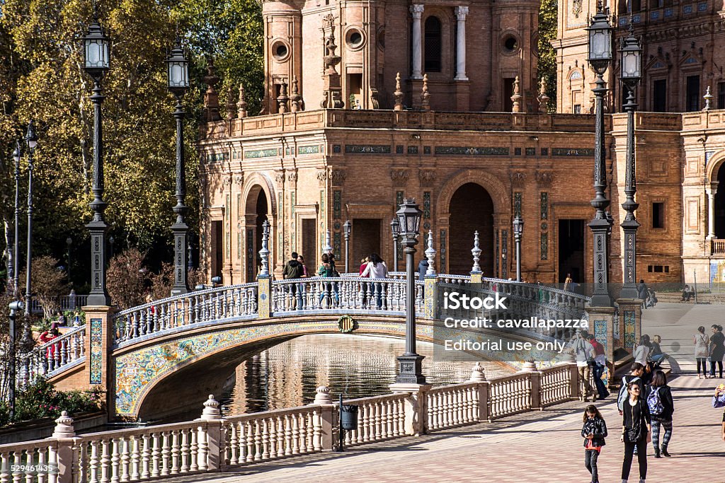 Seville, Spain - Plaza de Espana Seville, Spain - November 16, 2014: Plaza de Espana. The Sevillian and tourists visit the square on a sunny Sunday in November. The square has a channel that can be traveled on rowboats and small bridges to cross it on foot. Andalusia Stock Photo