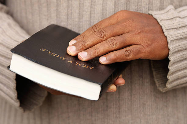 mann hält eine bibel - bible holding reading book stock-fotos und bilder